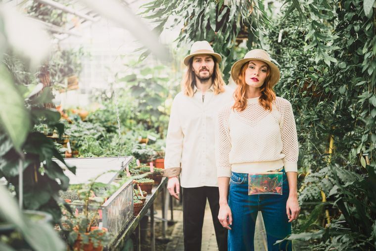 Woman and man wearing hats in a greenhouse Woman and man wearing hats in a greenhouse
